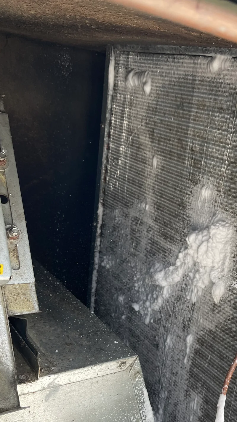 Foaming cleaner covering an exposed HVAC coil during a detailed cleaning visit.