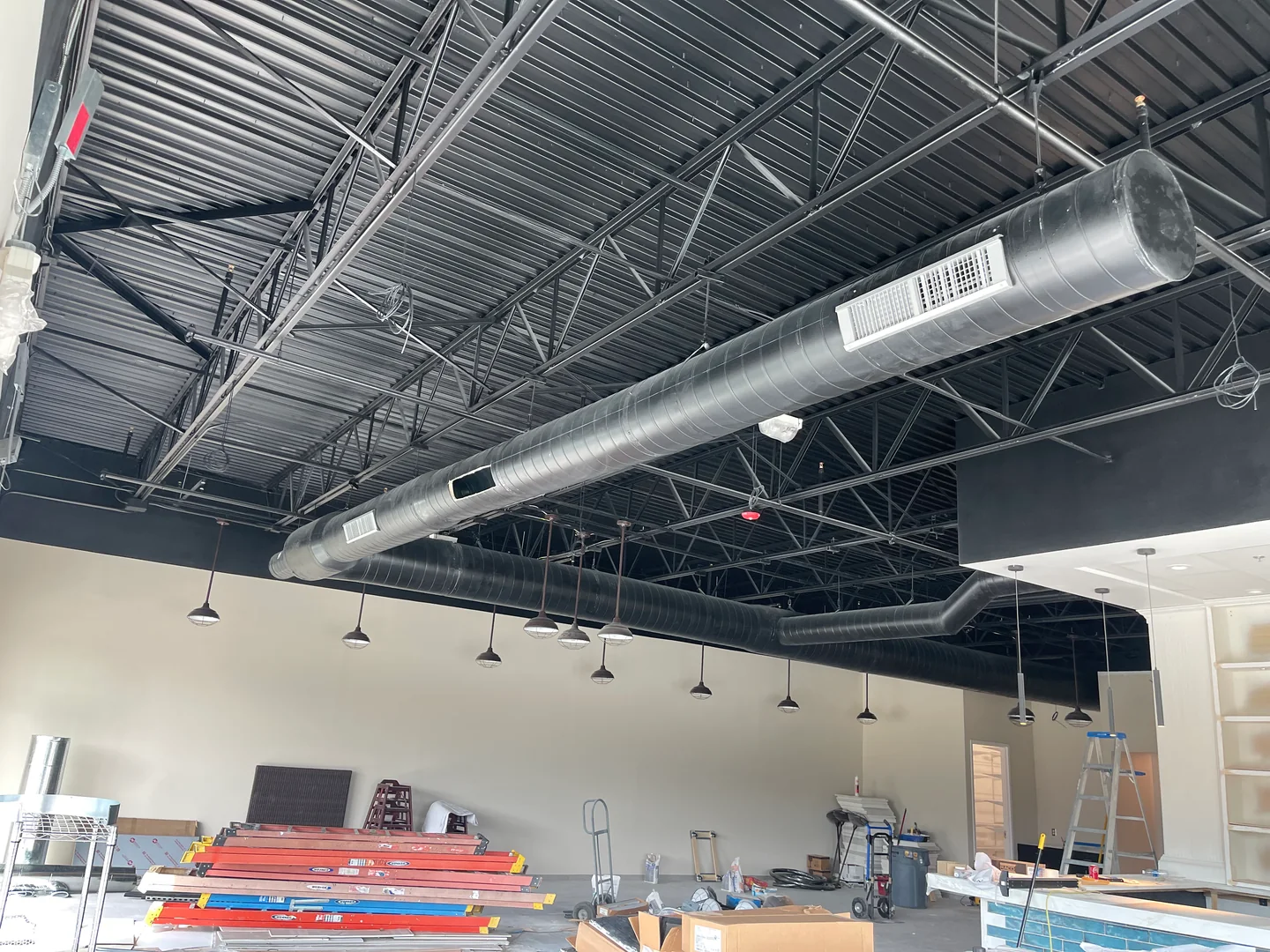 Close view of exposed spiral ductwork installed across a commercial ceiling.