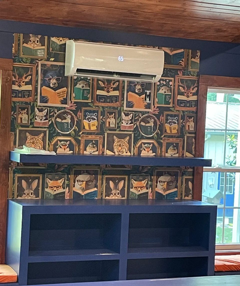 Wall-mounted ductless indoor unit installed high on a finished room wall.